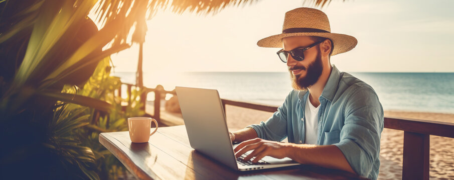 Cheerful young man working on a laptop on vacation. Copy space