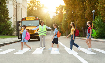Group of children passing crosswalk on their way to school bus - Powered by Adobe