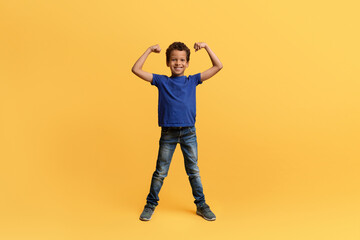 Strong athletic african american school aged boy showing his biceps
