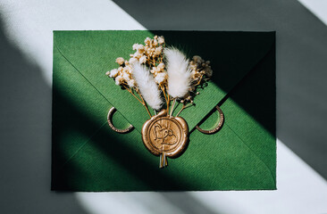 Wedding accessories, details: an envelope with a stamp, gold rings, boutonniere made of reeds and...