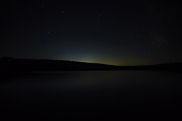 The night sky shot at a dock by a lake in a provincial park.