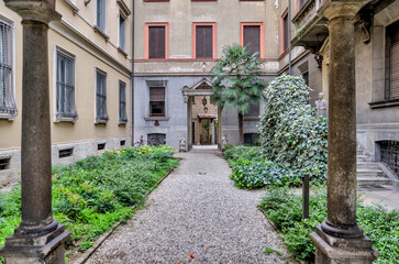 Fototapeta na wymiar Milan, Italy - July 12, 2022: An ornate corridor leading to a courtyard on the streets of Milan 