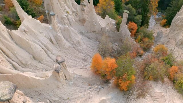 4k drone flight up footage (Ultra High Definition) of Earth pyramids of Platten - Spiky sand towers formed by water erosion and accessed by a woodland trail dotted with sculpture.