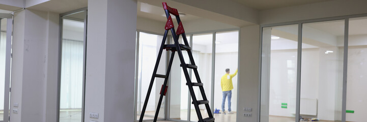 High ladder standing in center of empty office. - obrazy, fototapety, plakaty