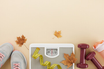 Fall slimming transformation theme. Top view shot of stylish sneakers, floor scales, tape measure, dumbbells, water bottle, dry maple leaves on pastel brown background with promo place
