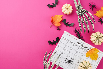 Honoring the enigmatic charm that heralds the Halloween season on 31th October. Top view photo of calendar, skeleton hands, pumpkins, autumn leaves, scary elements on pink background with ad spot