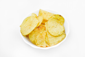 Yellow pieces of fried potatoes in a plate. Salted chips on a white background.