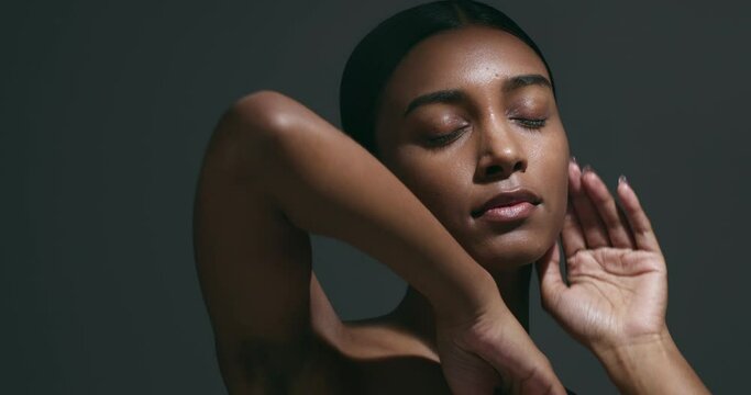 Skincare, sensual and woman in studio for natural, beauty and cosmetic facial treatment. Dermatology, clean and headshot of young Indian female model with glow moving isolated by a gray background.
