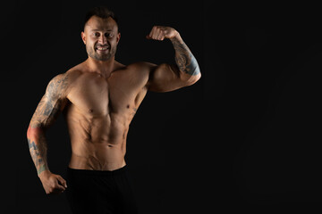 Fototapeta na wymiar Bodybuilder, strong athletic man. Fitness model, muscular and torso with abs. Isolated on a black background with copy space.