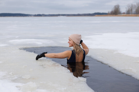 Winter Serenity: Swimming in Cold Waters by the Snow-Covered Lake with a Meditating Woman