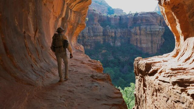 A man hiking and exploring a sandstone cave