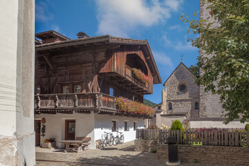 Fototapeta na wymiar Glimpses of ancient Dolomite town of San Candido Innichen, with traditional house and medieval church. Pusteria Valley, South Tyrol, Italy