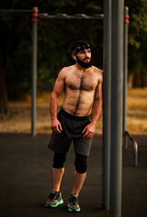A young man with a beard ,doing sports on a street,sports ground