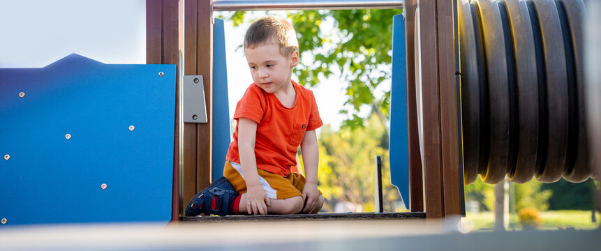 Cute toddler boy two or three years old is playing on the playground outside. Healthy summer activity for children. Children's games. Selective focus