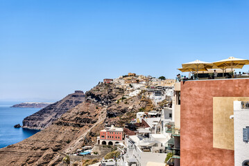 Fira, Greece - July 20, 2023: Cliffside buildings and walkways in the town of Fira on the island of...