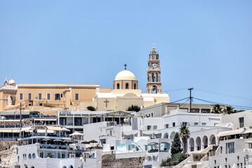 Fira, Greece - July 20, 2023: Cliffside buildings and walkways in the town of Fira on the island of...