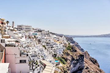 Fira, Greece - July 20, 2023: Cliffside buildings and walkways in the town of Fira on the island of...