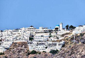 Fira, Greece - July 20, 2023: Domed churches and surrounding buildings in the town of Fira on the...