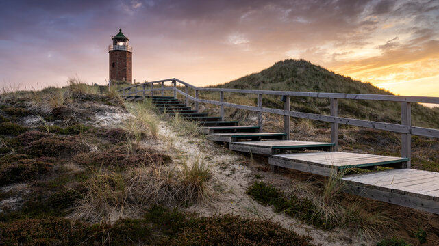 Farbenfroher Sonnenuntergang hinter dem kleinen Leuchtturm Quermarkenfeuer bei Kampen auf der Insel Sylt im Herzen der Nordsee