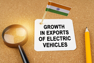 On the table is the flag of India and a sheet of paper with the inscription - growth in exports of electric vehicles