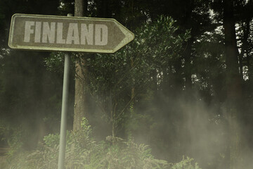 old signboard with text finland near the green sinister forest © luzitanija