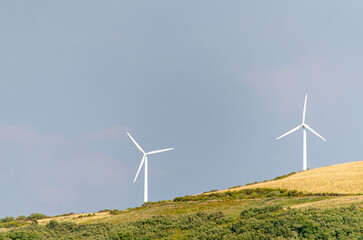 wind turbines of a mountain wind farm, green energy concept
