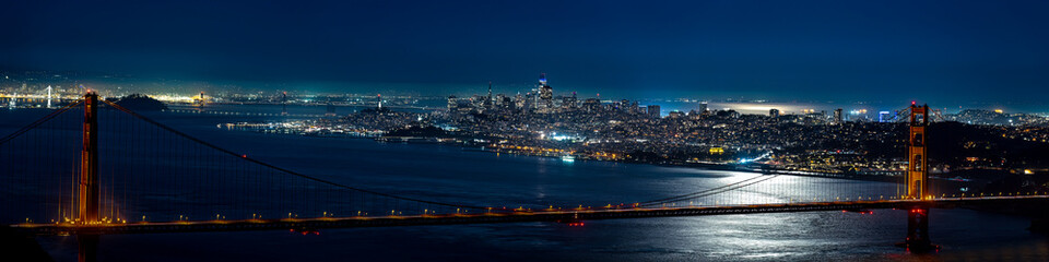 1x4 Panorama of the Golden Gate Bridge with San Francisco skyline at night. 