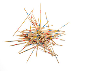 Mikado game on white, wooden pick-up sticks should be taken without moving the others, metaphor in...