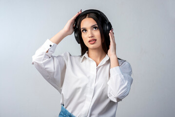 latin young woman with headphones very happy gesturing cheerful wearing white shirt and white background