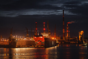 Twilight industrial factory landscape. The pipes over water.