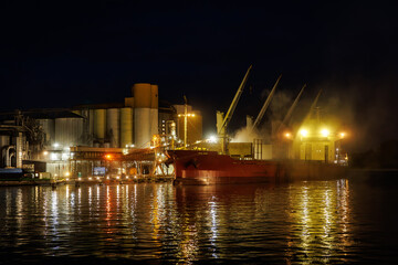 Fototapeta na wymiar Night loading of grain into a cargo ship.