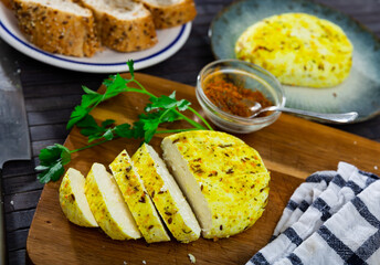 Sliced appetizing fried flavorful cottage cheese seasoned with cumin seeds and turmeric on wooden...