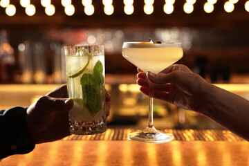 People holding glasses with fresh cocktails at bar counter, closeup