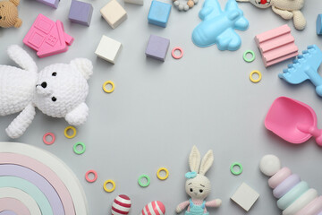 Frame of different children's toys on light grey background, flat lay. Space for text