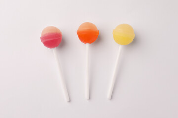 Tasty lollipops on white background, flat lay