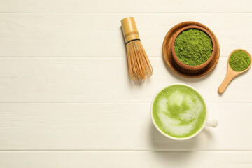Flat lay composition with tasty matcha latte on white wooden table, space for text