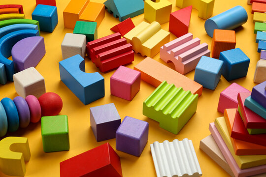 Different colorful children's toys on yellow background