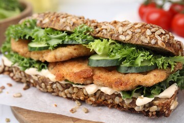 Delicious sandwich with schnitzel on white table, closeup