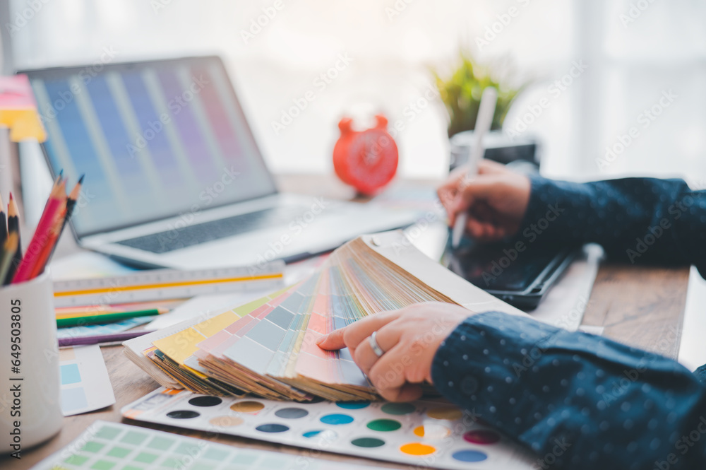 Fototapete Graphic designer architects who work with laptops and color comparison tables for design work..