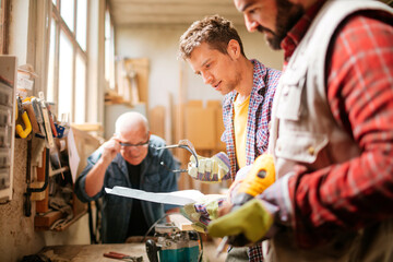 Diverse age group of carpenters working in a carpenter shop