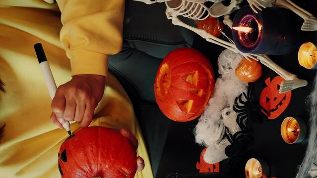 Woman with painted orange pumpkin or jack-o-lantern in hands. Vertical video