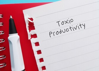 Pencil writing on notebook written  TOXIC PRODUCTIVITY, means desire for productivity at all times,...