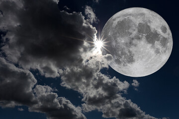 Close-up photo looking up at a large full moon partially covered by clouds. Copy space