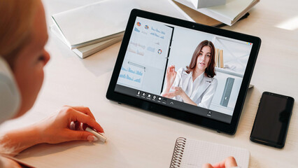 Video lesson. Online education. Business webinar. Digital class. Female student at internet coach woman presentation on tablet screen with charts graphs at home workplace.