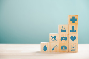 Wooden cubes in pyramid shape, illustrating the healthcare and insurance concept. Icon of medical insurance atop signifies protection. Blue background with copyspace for Health Insurance theme.