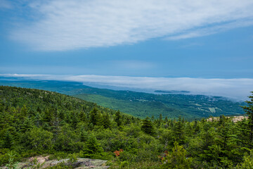 Beautiful scenic view from the top of the mountain. Lots of nature and green trees and clouds.