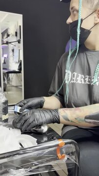 Tattoo artist makes a tattoo to a client