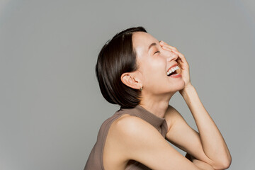 Fototapeta premium 手を顔にあてて笑っているミドル女性の横顔