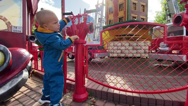 toddler child in amusement park Divo Ostrov, St. Petersburg, Russia, attraction Fire brigade