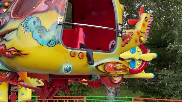 brave pilot toddler child in amusement park, attraction colorful airplanes will lift children Divo Ostrov, St. Petersburg, Russia